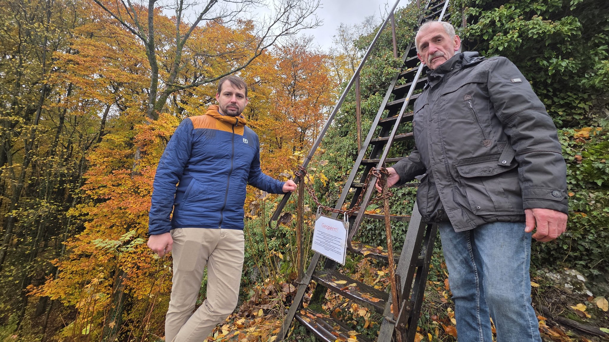 Waldbesitzer Michael Endres und sein Vater stehen vor dem Adlerstein, an dem sie eine Kette mit Schloss angebracht haben. | Bild: BR / Ulrike Nikola Waldbesitzer Michael Endres und sein Vater stehen vor dem Adlerstein, an dem sie eine Kette mit Schloss angebracht haben.