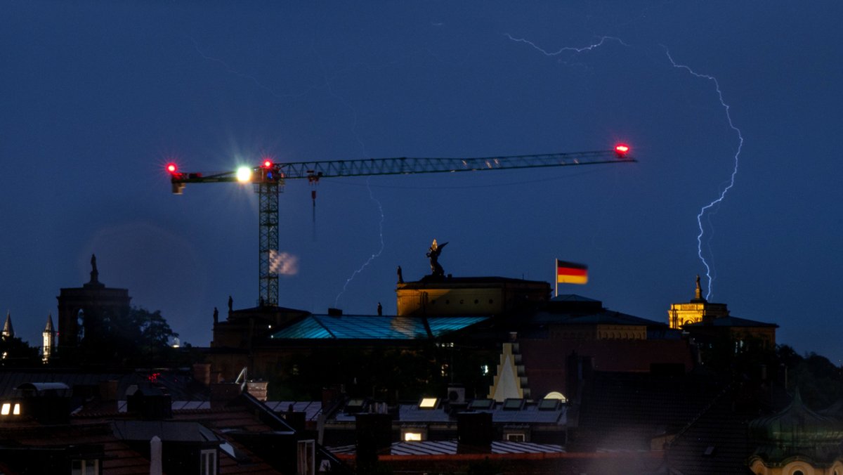 Ein Gewitter zieht in den Abendstunden mit Blitzen über die Dächer der bayerischen Landeshauptstadt und den bayerischen Landtag.
