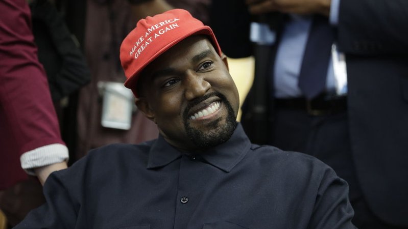 Der US-Rapper Kanye West sitzt während eines Treffens mit US-Präsident Trump und anderen im Oval Office im Weißen Haus und trägt dabei eine rote Mütze mit der Aufschrift "Make Amerika Great Again". | Bild: dpa-Bildfunk/Evan Vucci Der US-Rapper Kanye West sitzt während eines Treffens mit US-Präsident Trump und anderen im Oval Office im Weißen Haus und trägt dabei eine rote Mütze mit der Aufschrift "Make Amerika Great Again".