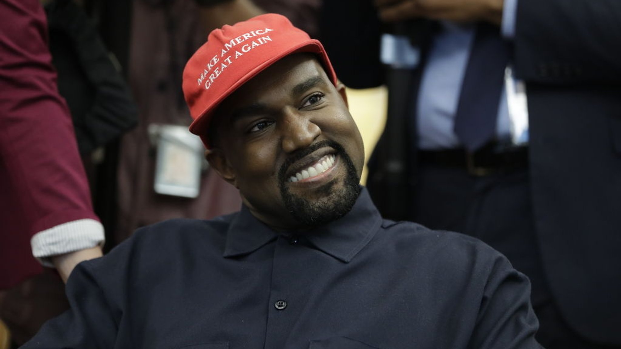 Der US-Rapper Kanye West sitzt während eines Treffens mit US-Präsident Trump und anderen im Oval Office im Weißen Haus und trägt dabei eine rote Mütze mit der Aufschrift "Make Amerika Great Again".