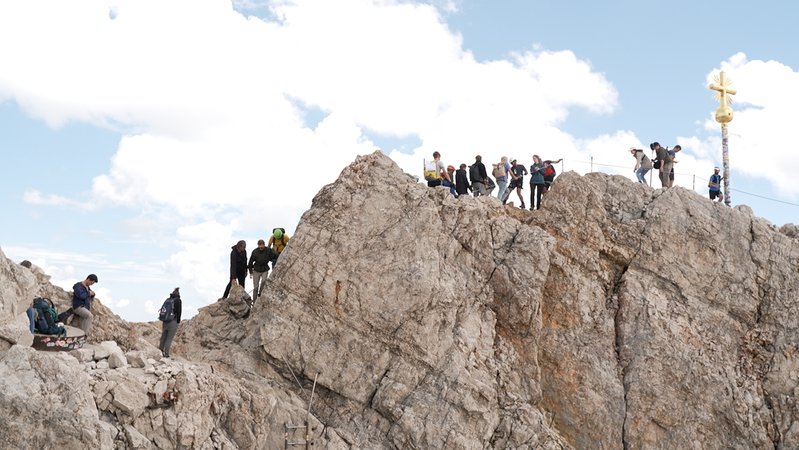 Viele Menschen drängen sich auf dem Klettersteig zum echten Gipfelkreuz. | Bild: BR/Martin Breitkopf Viele Menschen drängen sich auf dem Klettersteig zum echten Gipfelkreuz.