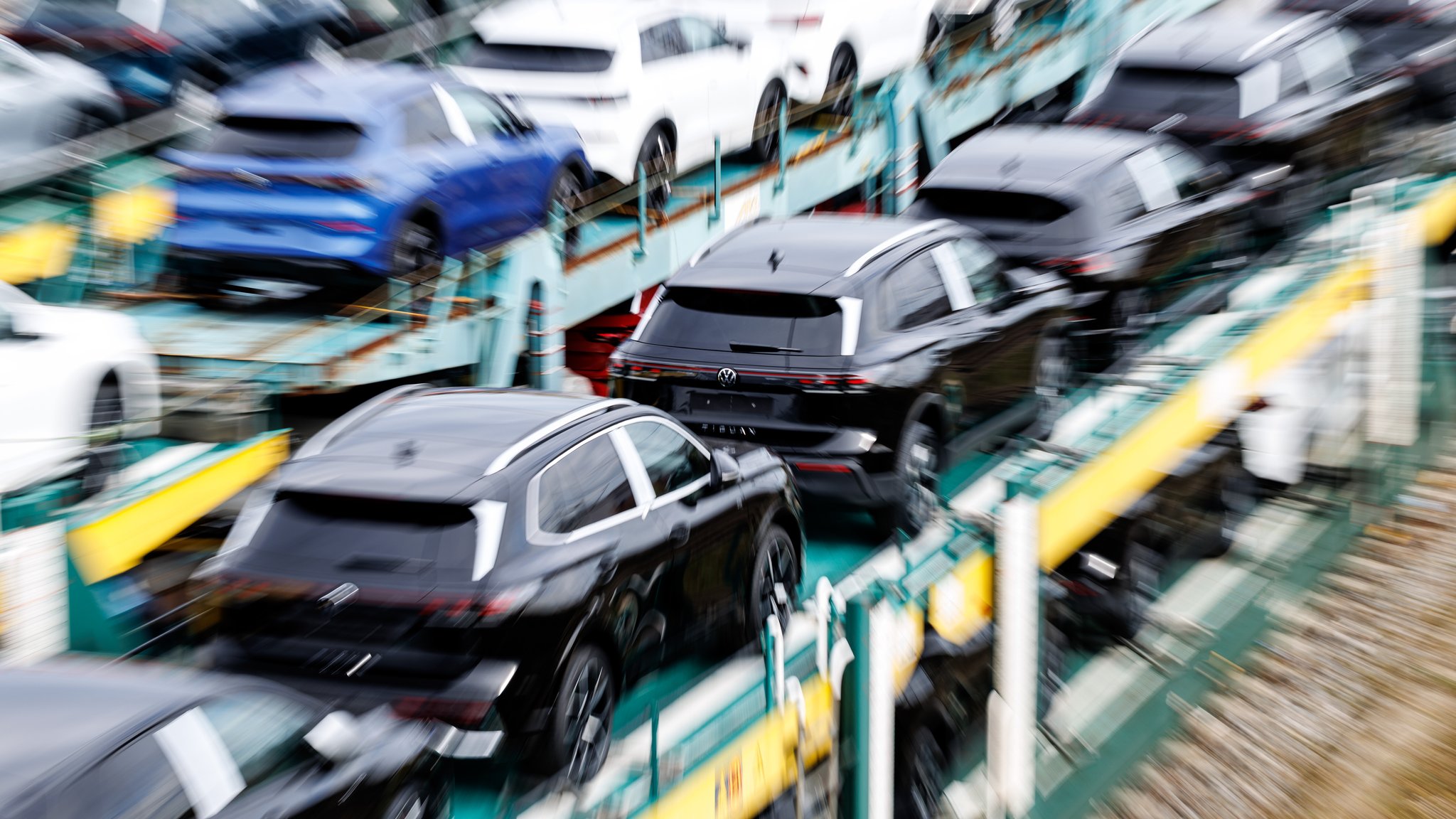 Neue Autos stehen auf einem Zug und warten auf ihren Transport.