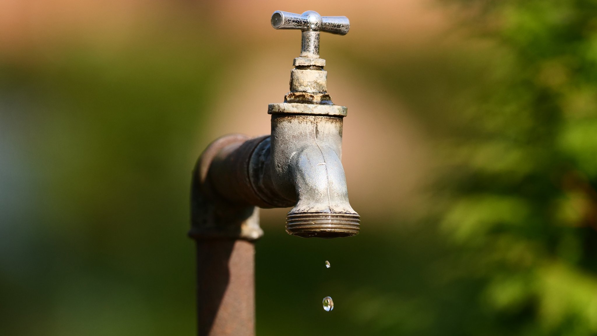 (Symbolbild) Ein alter Wasserhahn im Außenbereich tropft. 