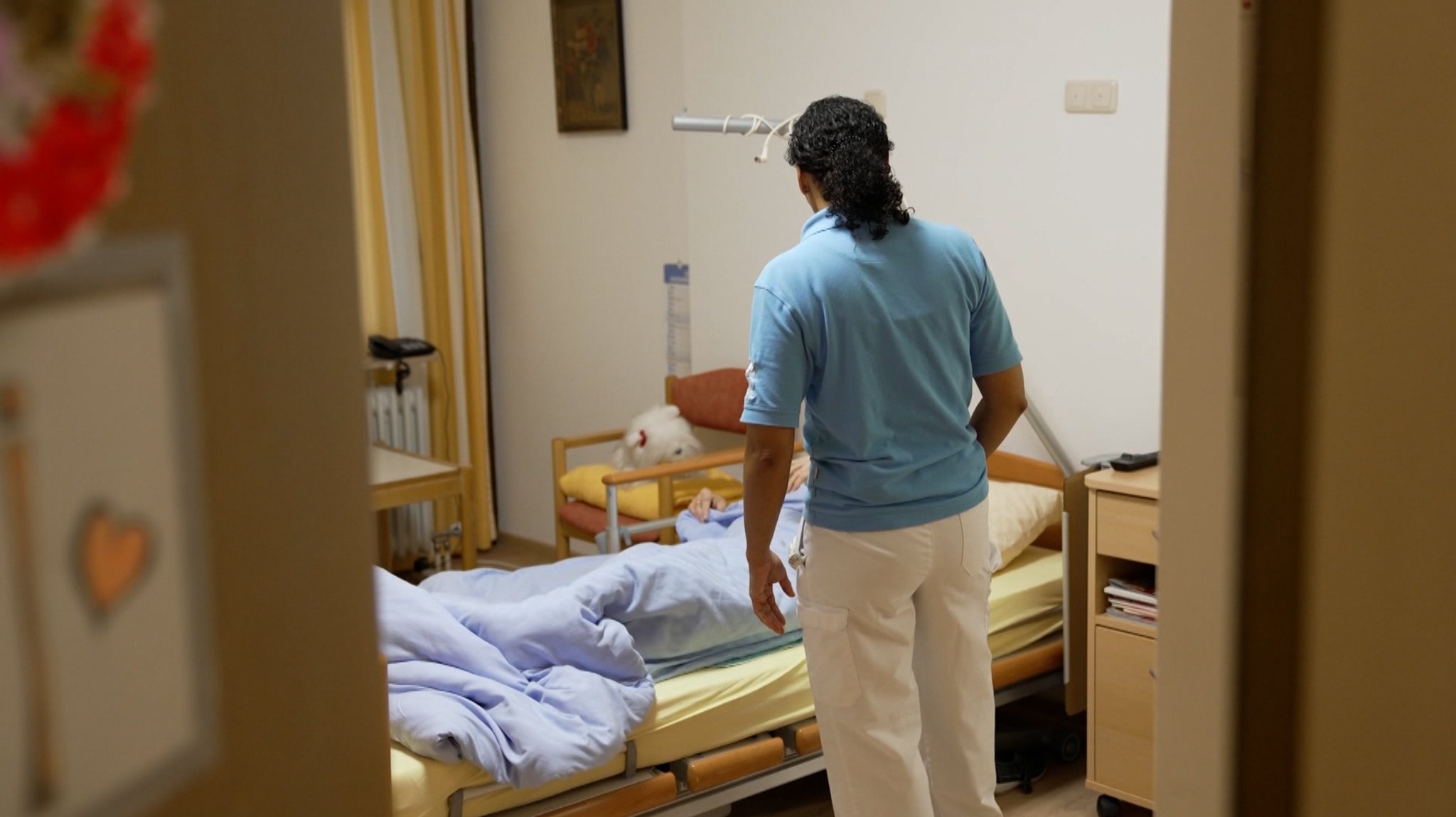 (Symbolbild) Ein Pfleger steht vor einem Krankenbett