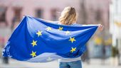 Eine junge Frau hält eine Europaflagge. | Bild:stock.adobe.com/weyo