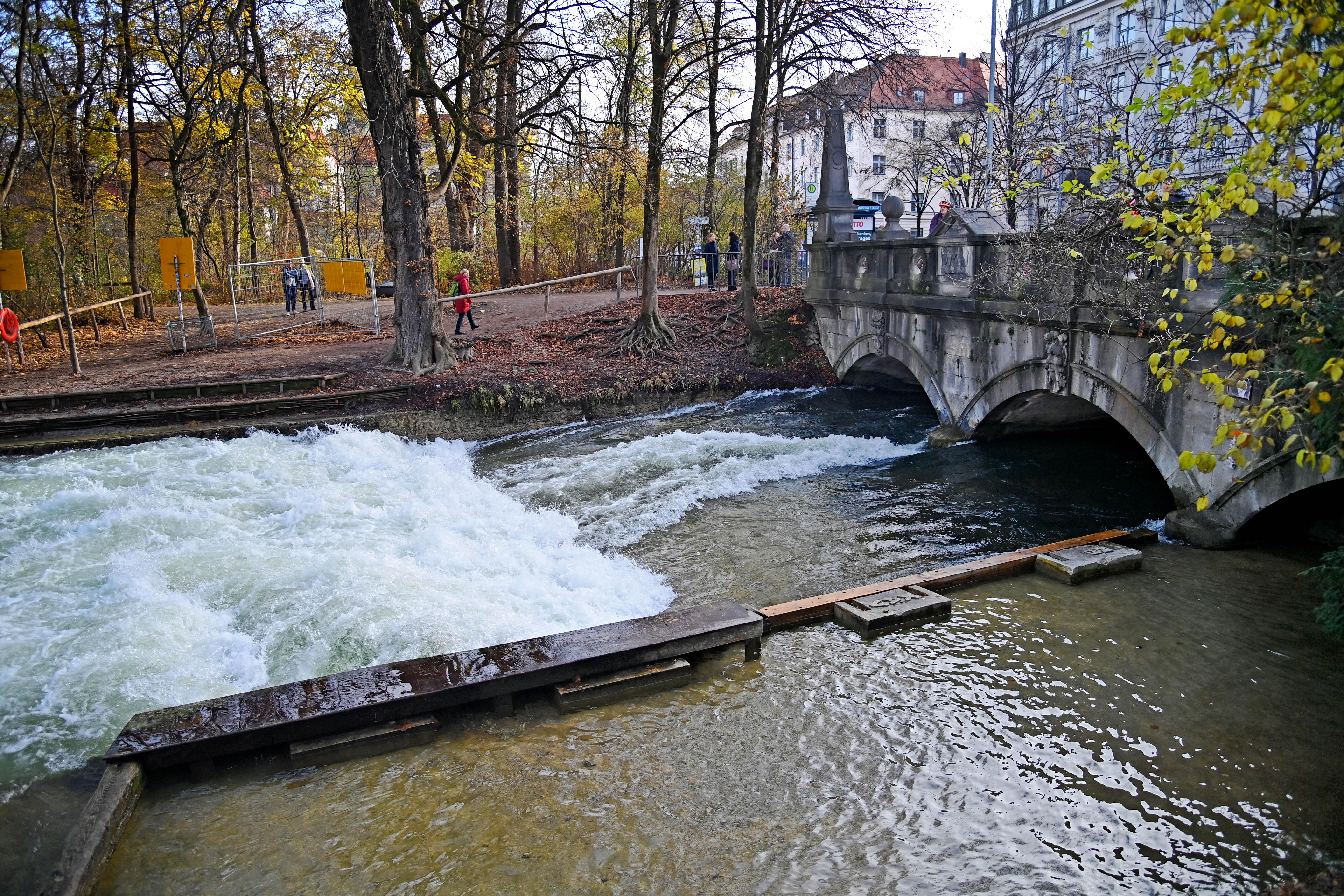 Der Münchner Eisbach an der Stelle, wo er unter der Prinzregentenstraße austritt. Das Wasser schäumt, aber es ist keine Welle zu sehen. 