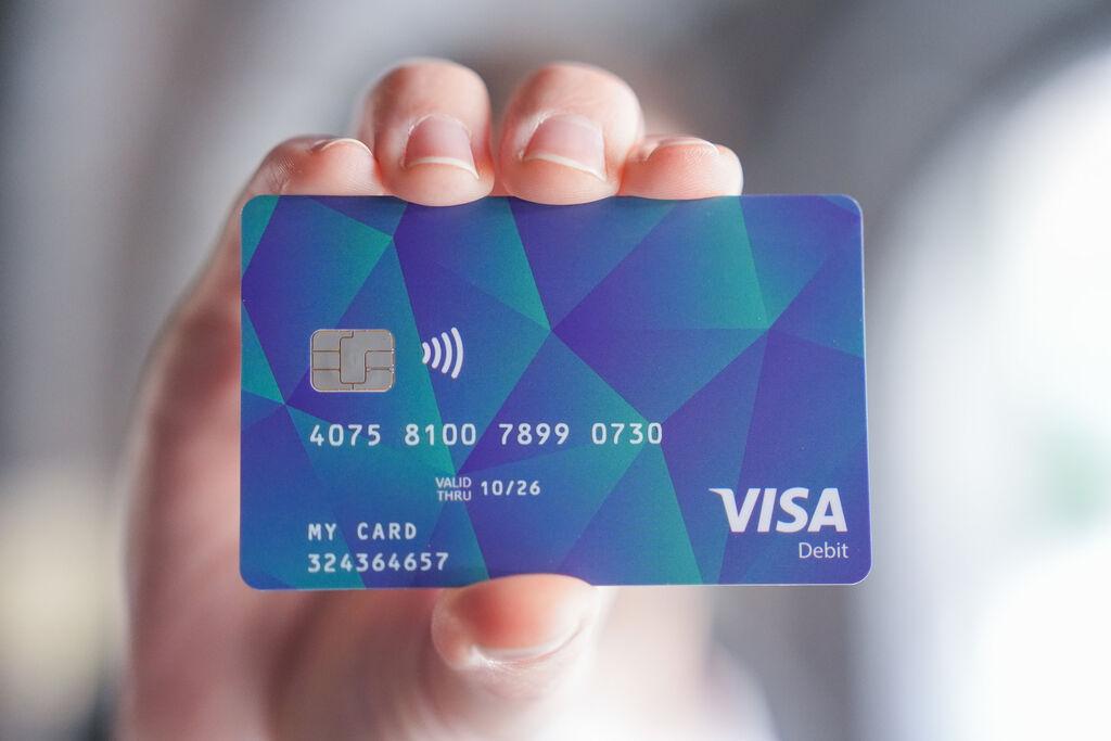 Ein Mann hält eine Bezahlkarte für Asylsuchende in der Hand.