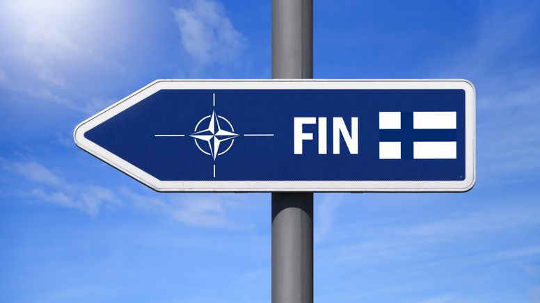 Wegweiser mit der Fahne von Finnland und Zeichen der NATO | Bild:picture alliance / CHROMORANGE | Christian Ohde