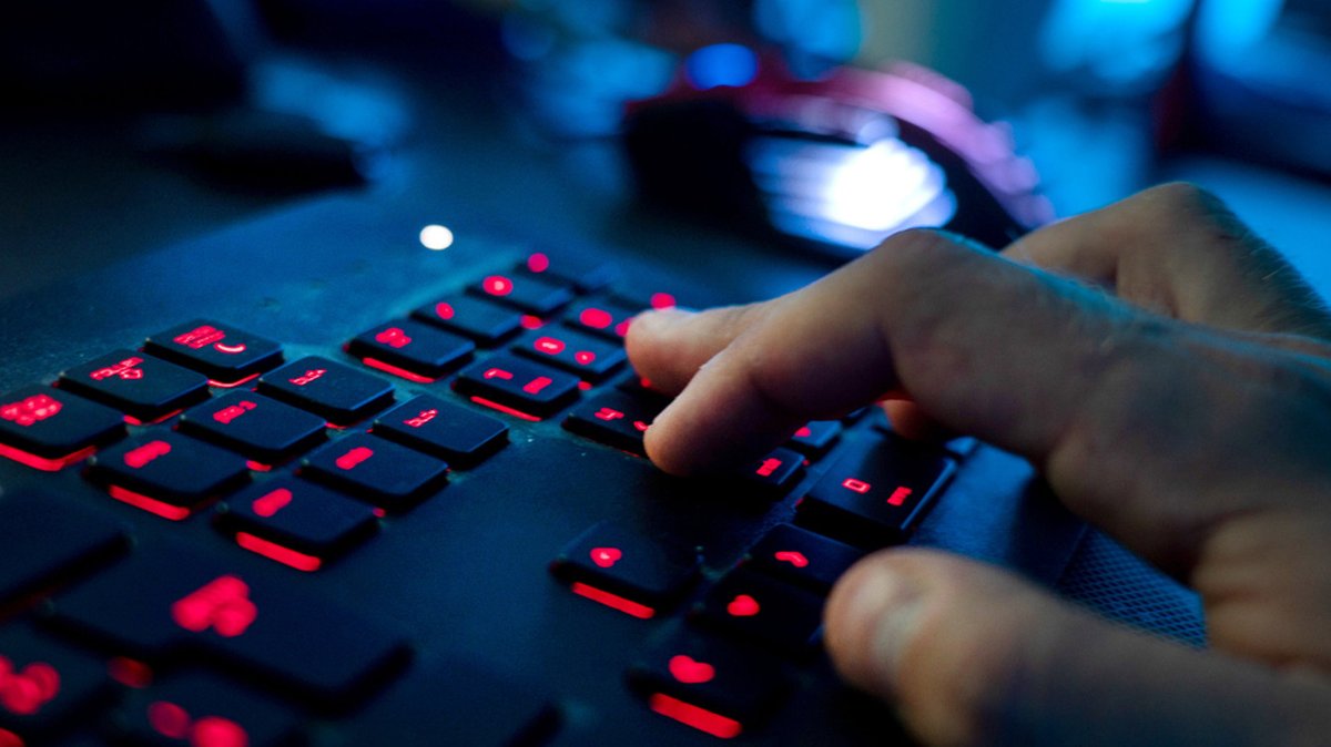Mann sitzt am Rechner und tippt auf einer Tastatur. Kriminelle Hacker haben Unternehmen im Visier (Symbolbild)
