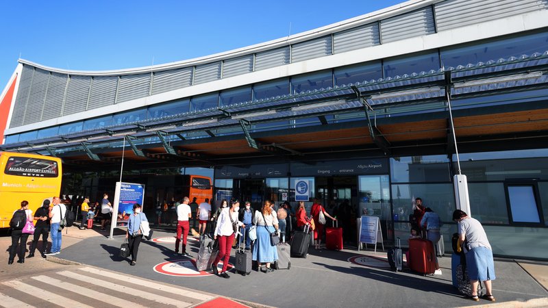 Fluggäste stehen vor dem Terminal des Allgäu Airports