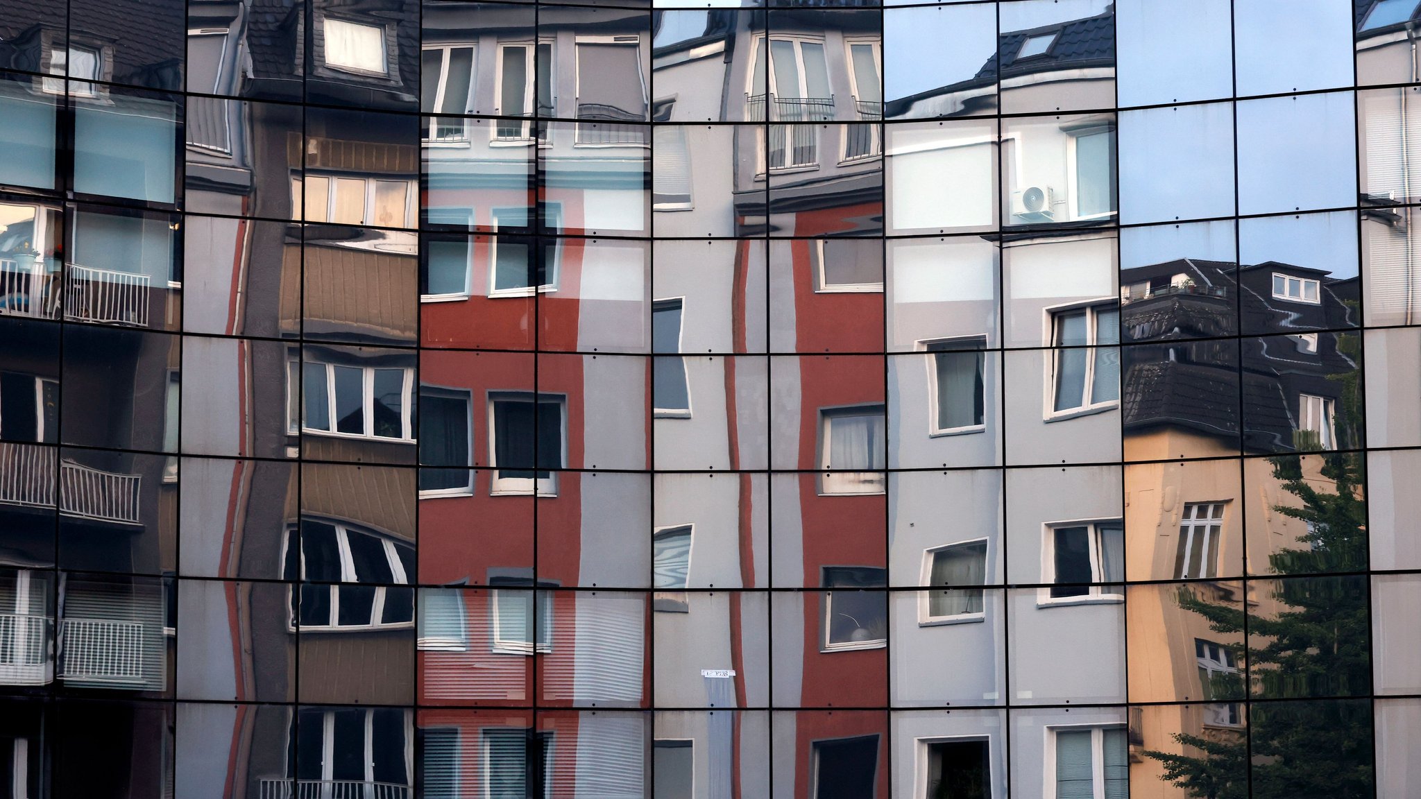 Häuser spiegeln sich in einer Fassade.