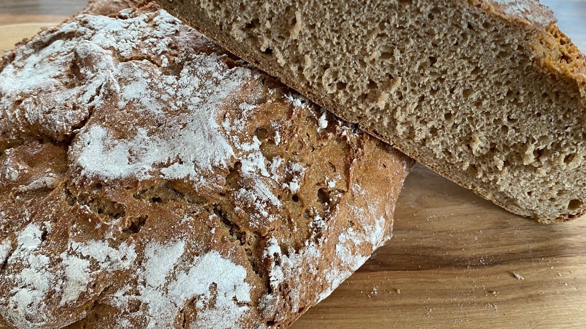 Ein aufgeschnittener Laib "Berchtesgadener Land Brot" liegt auf einem ganzen Laib.