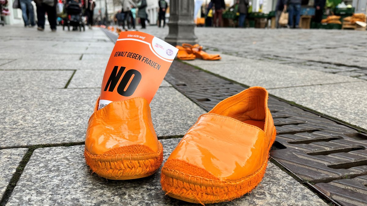 Ein paar orange lackierte Schuhe steht in der Fußgängerzone Coburg.