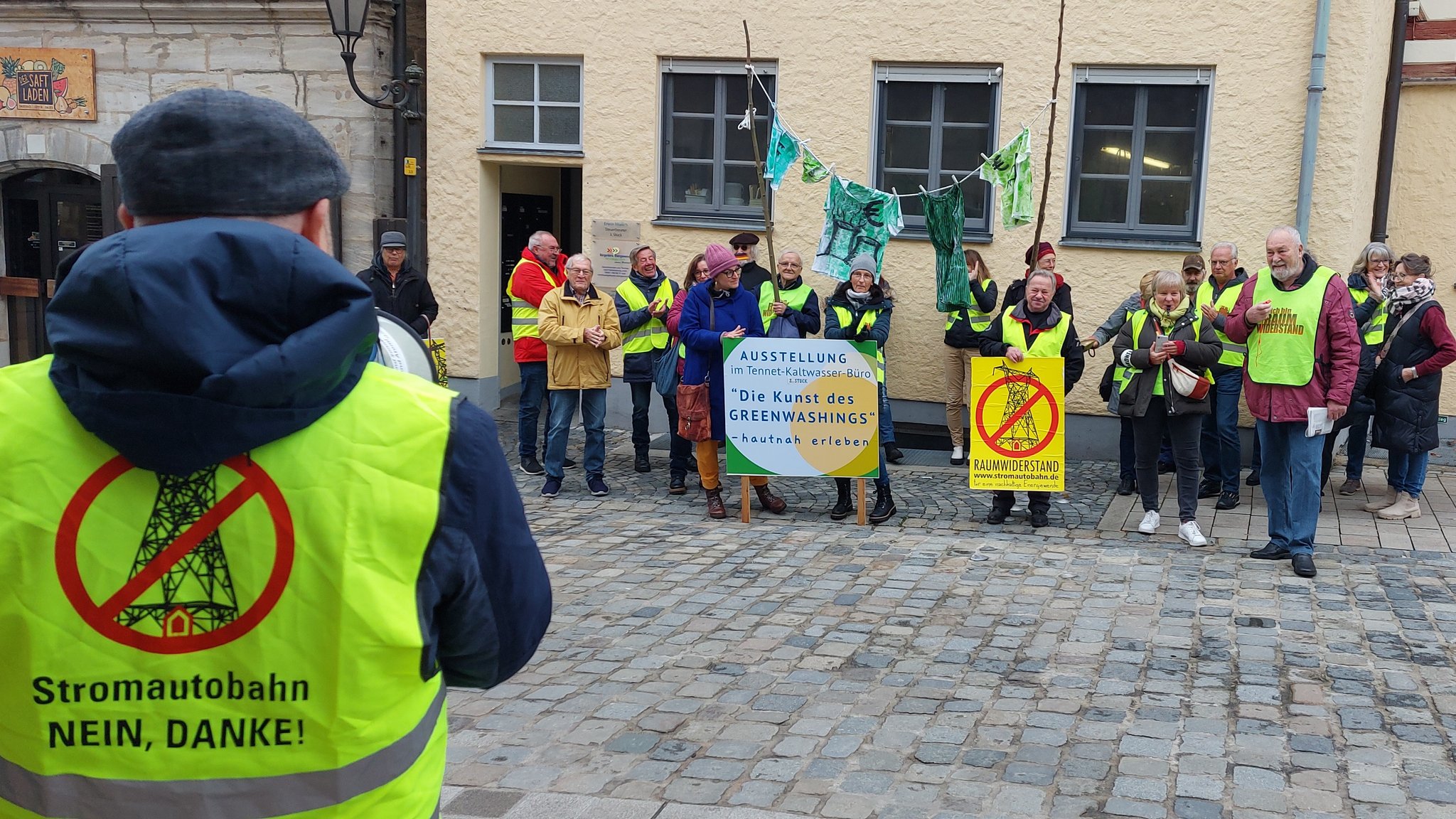 Mahnwache der Trassengegner in gelben Warnwesten von dem "Bürgerbüro Energiewende Altdorf".