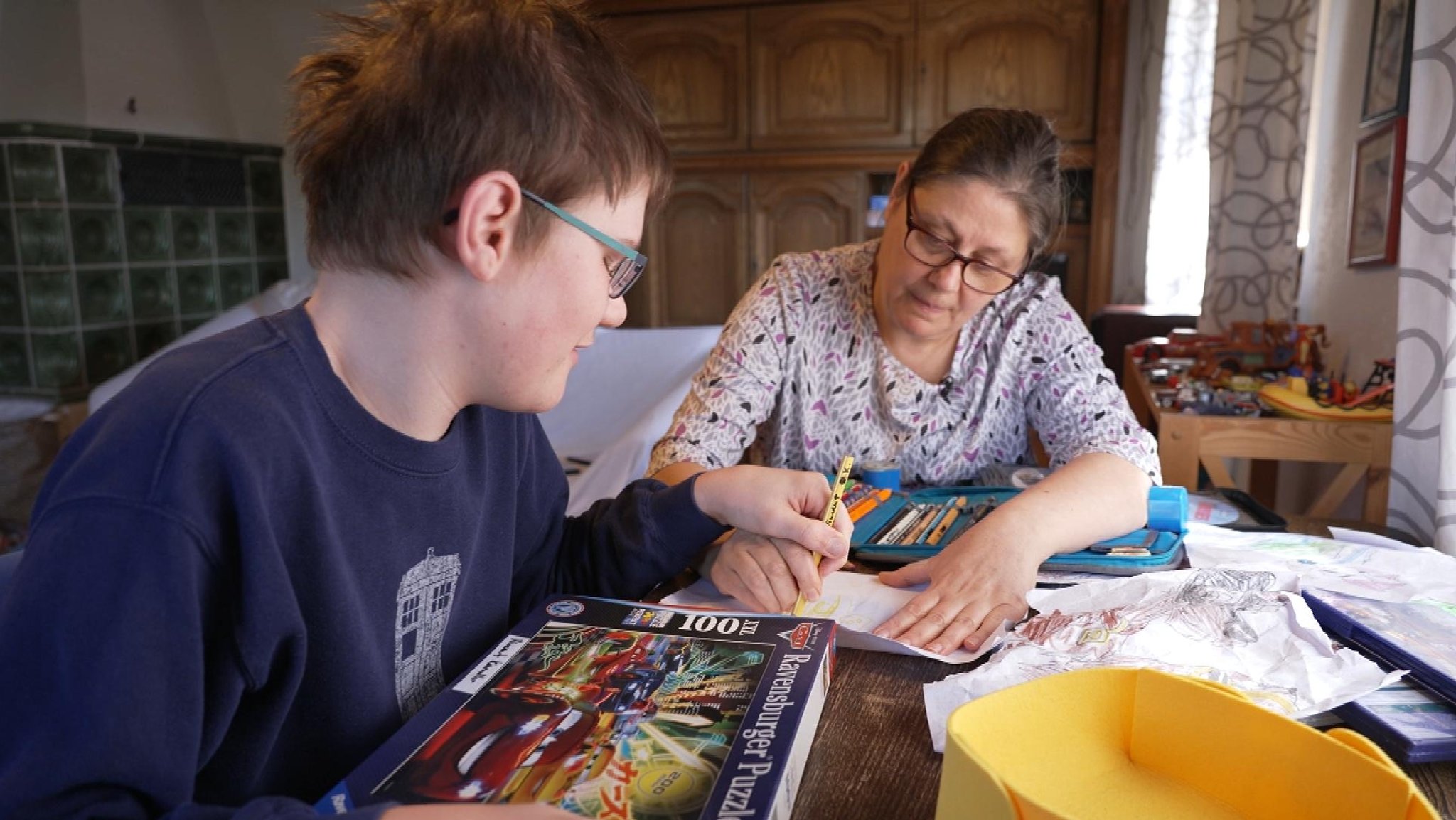 Vincent Kaendler und seine Mutter Carolina sitzen an einem Tisch und malen gemeinsam.