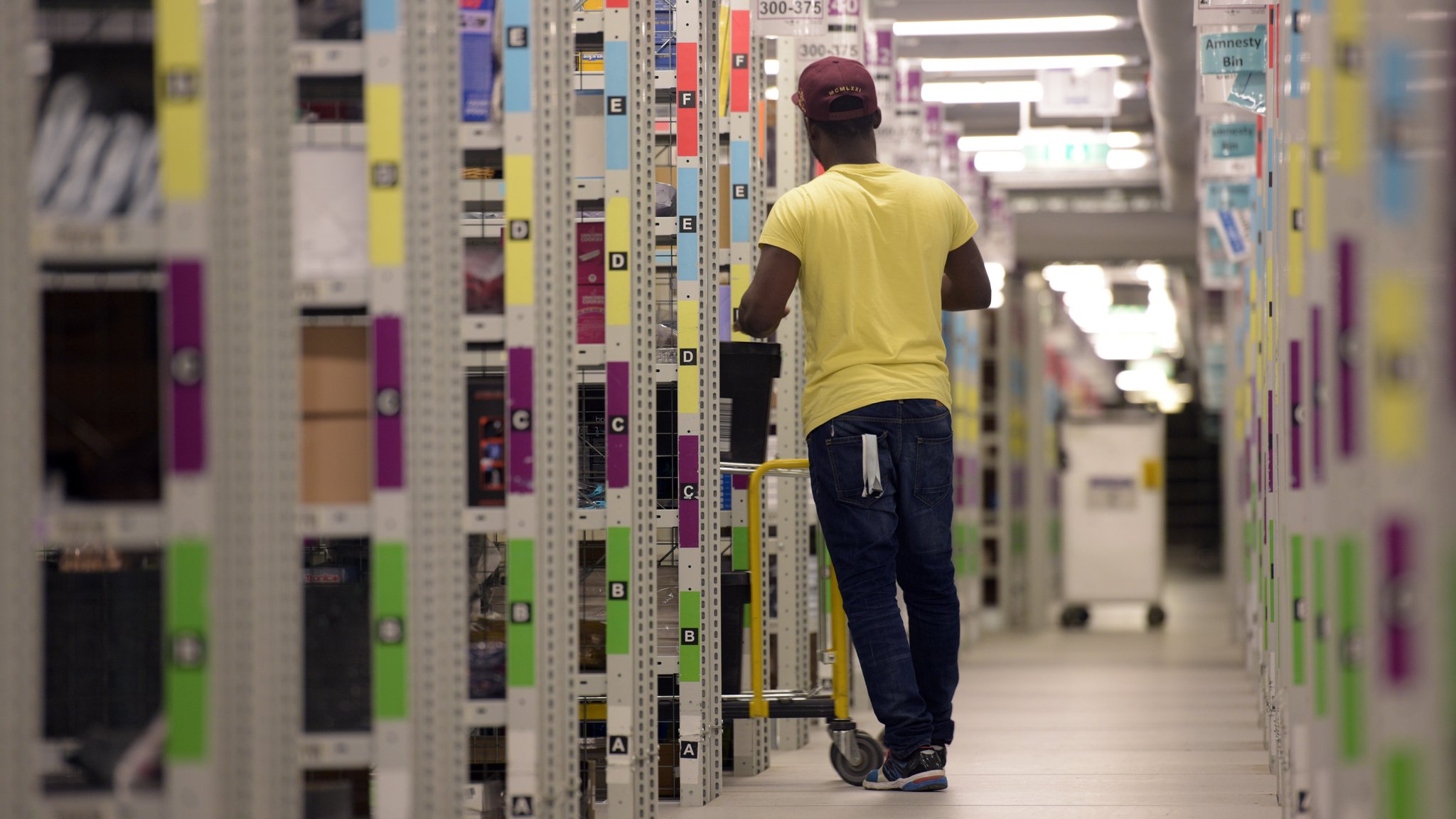 In langen Regalreihen lagern im Logistikzentrum Graben bei Augsburg Artikel vor ihrem Versand. In diesem Logistikzentrum arbeiten gut 1.900 Mitarbeiter.