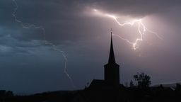 Ein Blitz ist über einer Ortschaft in Bayern zu sehen. Der Deutsche Unwetterdienst warnt nun erneut vor lokalen Gewittern. | Bild:pa/Nicolas Armer