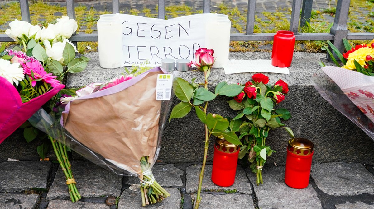 01.06.2024, Baden-Württemberg, Mannheim: Kerzen, Blumen und ein Blatt Papier mit der Aufschrift ·Gegen Terror· stehen am Tatort auf dem Marktplatz.
