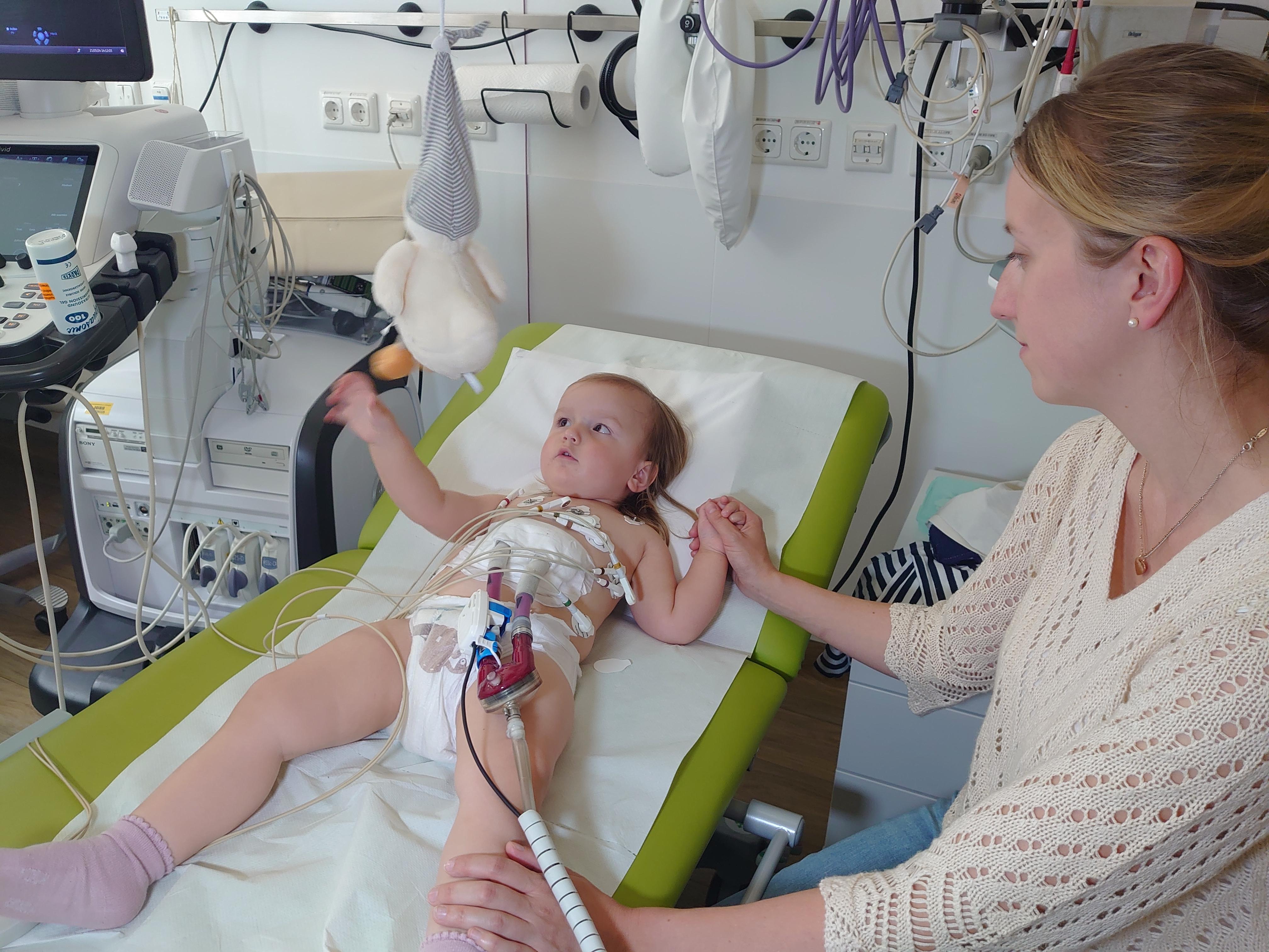 Lena liegt in der Uniklinik auf einer Behandlungsliege, während eine Ultraschalluntersuchung vorbereitet wird.