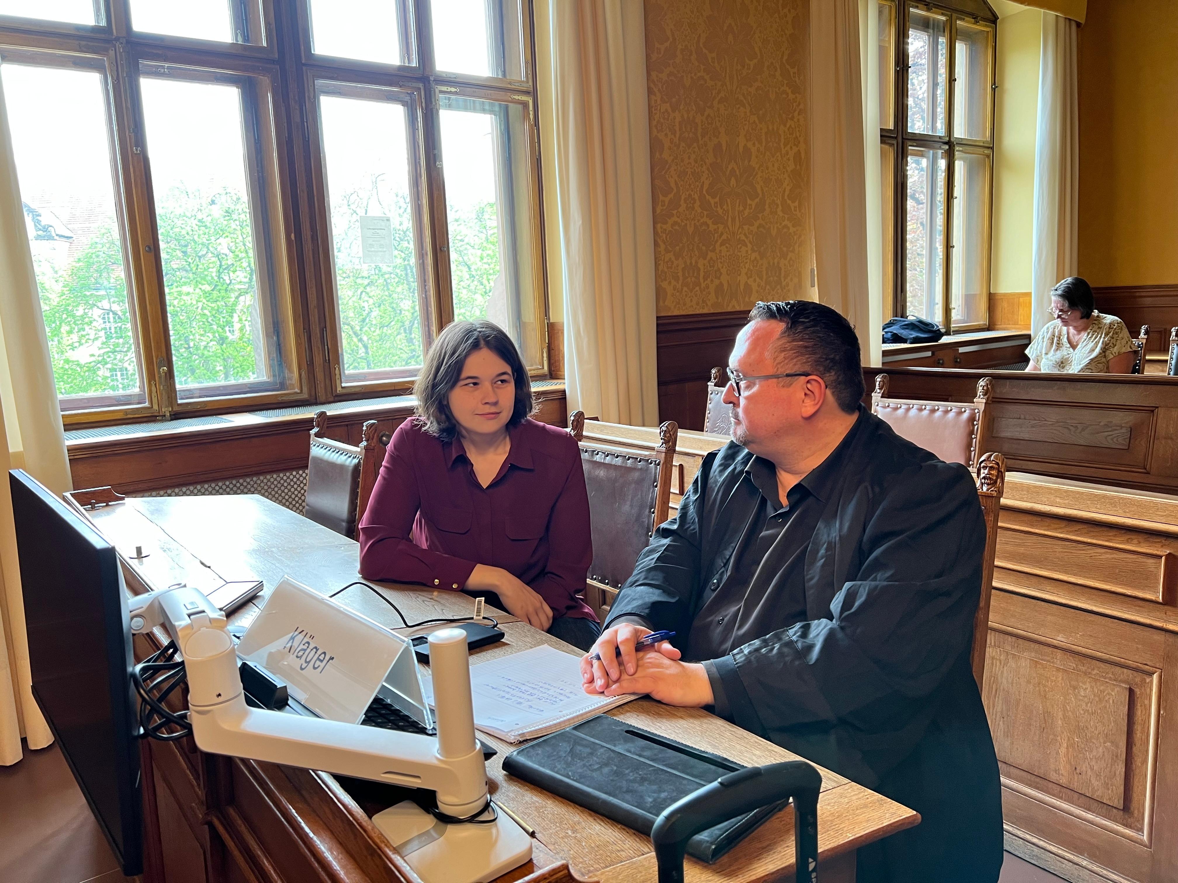 Eine 33-jährige Frau aus Hof sitzt in einem Gerichtssaal neben ihrem Anwalt Volker Loeschner.