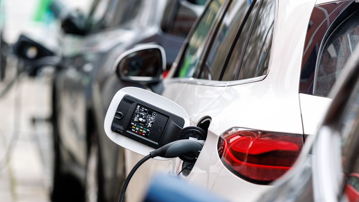 E-Autos verschiedener Hersteller sind an Ladesäulen am Straßenrand im Stadtzentrum von München angeschlossen.