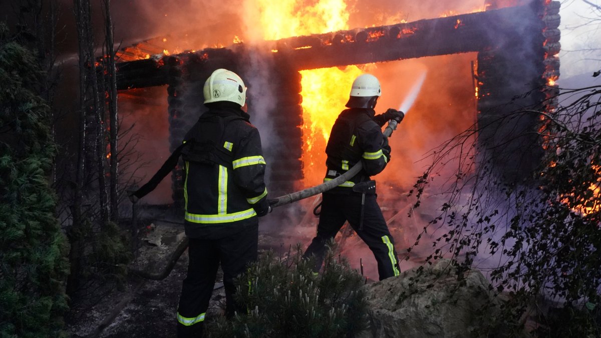 Ukraine, Charkiw: Feuerwehrleute löschen ein Feuer, nachdem ein Haus von russischem Beschuss getroffen wurde.