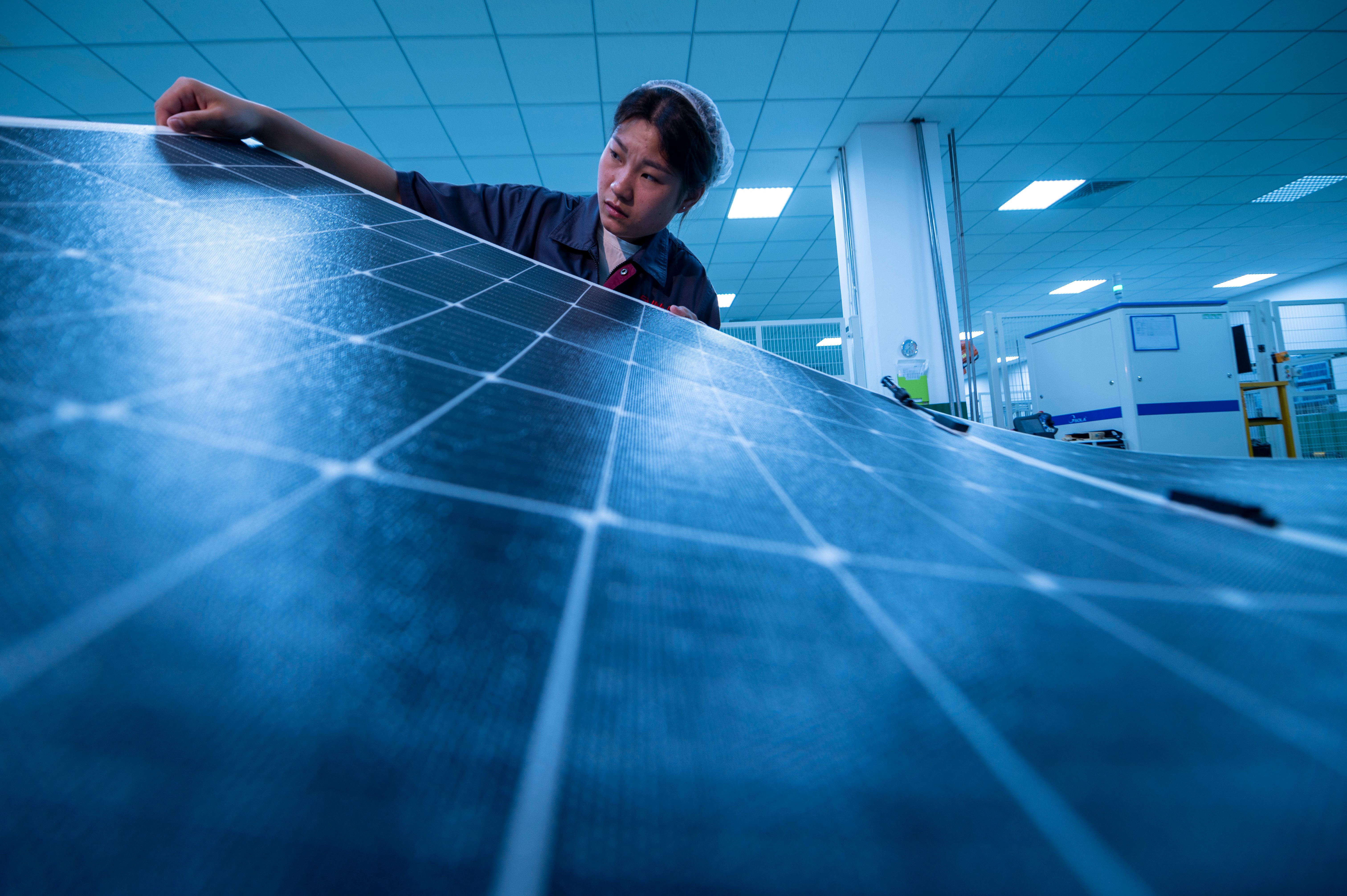 Chinesische Arbeiterin mit Solar-Paneelen