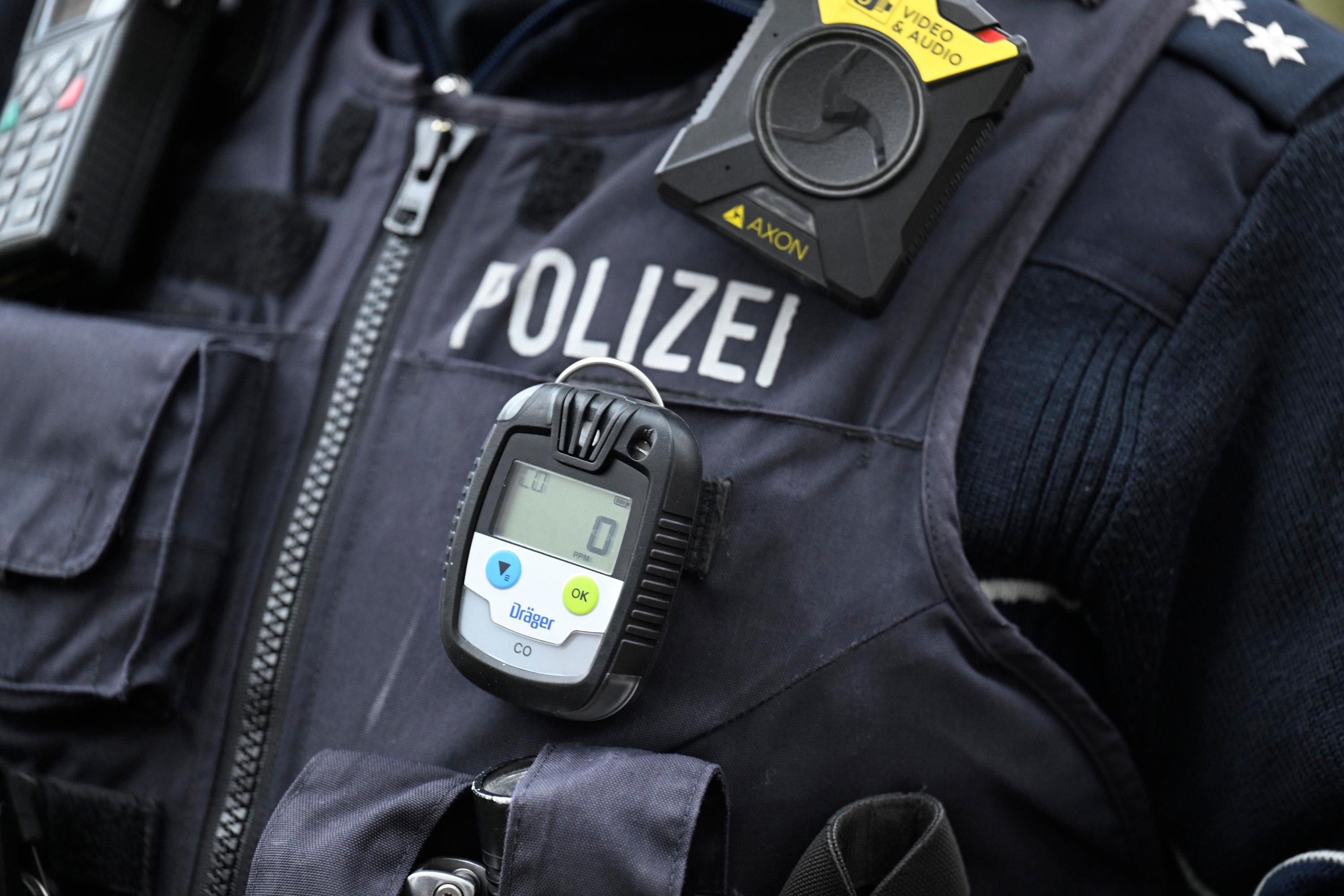Eine Polizistin trägt einen CO-Melder am Revers.