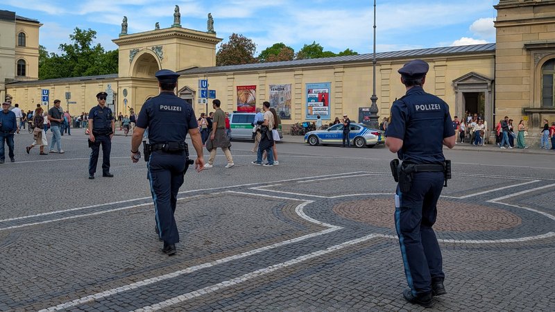 Zwei Polizeibeamte in blauer Uniform laufen auf dem Münchner Odeonsplatz auf einen dritten zu (Archiv-, Symbolbild). | Bild: picture alliance / NurPhoto | Michael Nguyen Zwei Polizeibeamte in blauer Uniform laufen auf dem Münchner Odeonsplatz auf einen dritten zu (Archiv-, Symbolbild).