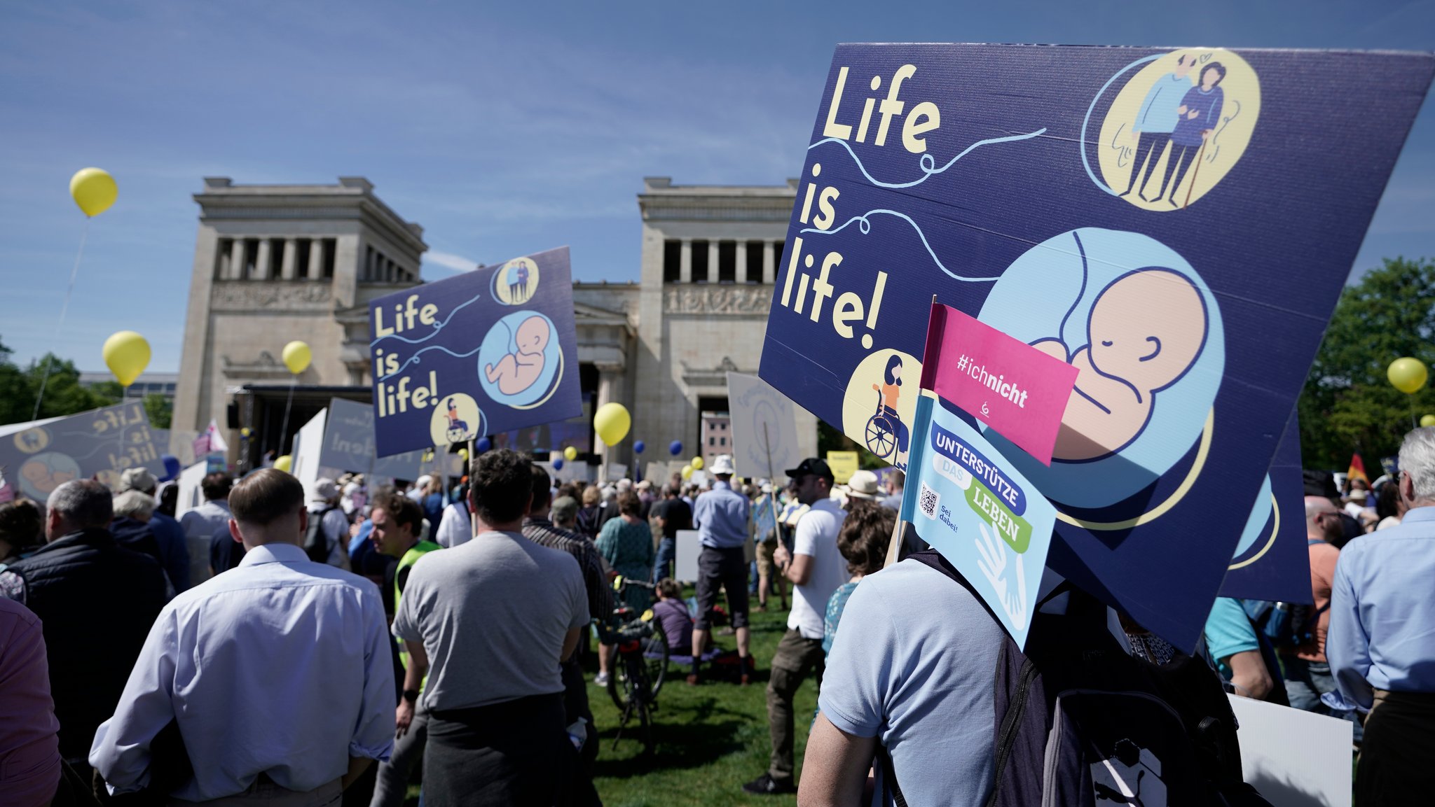 Teilnehmer der Kundgebung "Marsch fürs Leben" stehen mit Transparenten "Life is life" am Königsplatz.