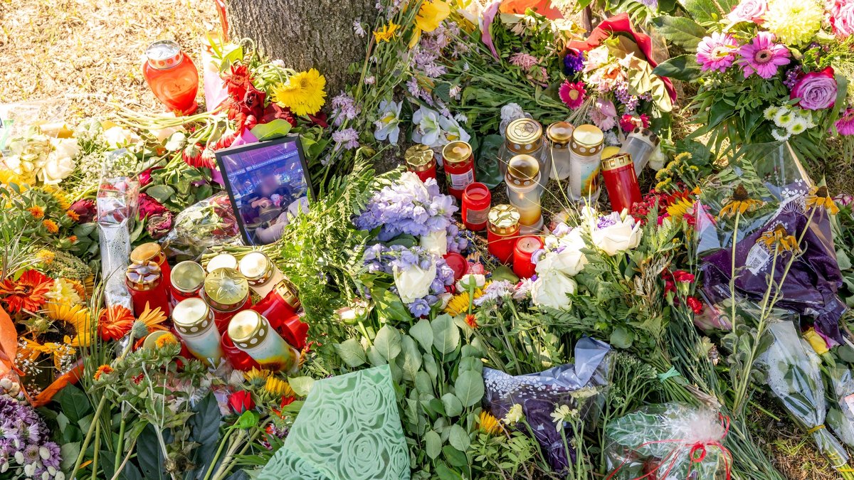 Blumen, Kerzen und ein Bild der Ermordeten liegen an einem Baum, in dessen Nähe am 17. August 2022 eine weibliche Leiche in einem Auto entdeckt wurde. 