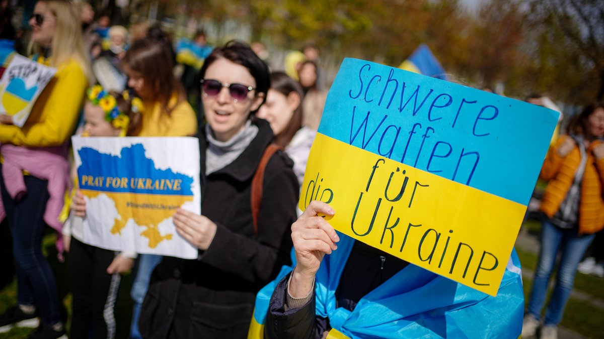 Menschen aus der Ukraine demonstrieren vor dem Bundeskanzleramt gegen den Krieg in ihrer Heimat und fordern auf Transparenten die Lieferung schwerer Waffen.