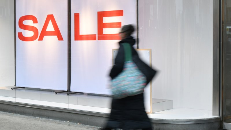 Der Schriftzug "Sale" steht im Schaufenster eines Bekleidungsgeschäftes. Eine Frau hastet vorbei. | Bild: pa/dpa/Ella Wenzel Der Schriftzug "Sale" steht im Schaufenster eines Bekleidungsgeschäftes. Eine Frau hastet vorbei.