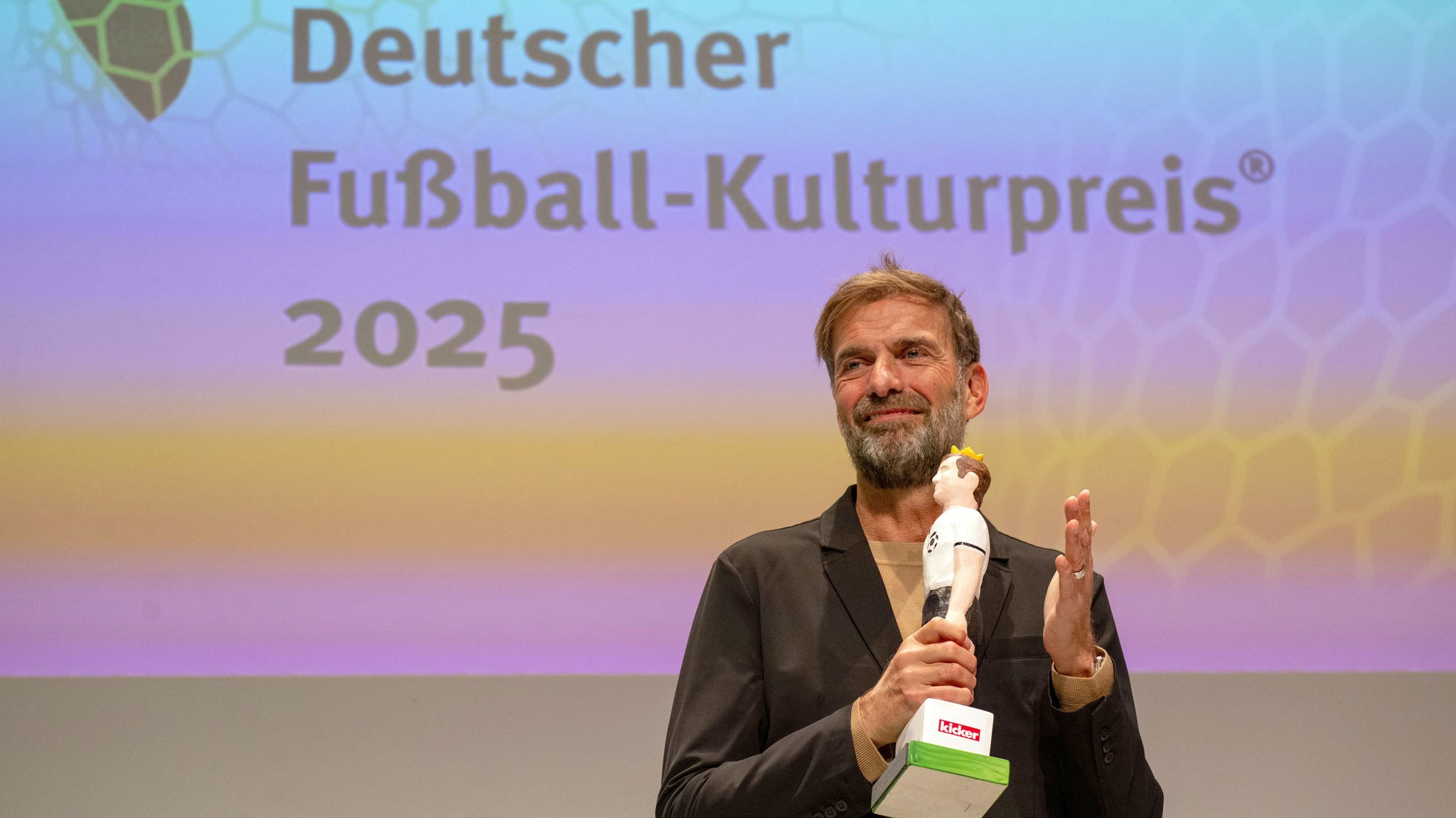 24.10.2025, Bayern, Nürnberg: Jürgen Klopp, ehemaliger Fußballspieler und -trainer sowie Global Head of Soccer bei Red Bull, klatscht bei der Verleihung des Deutschen Fußball-Kulturpreises in Nürnberg. Klopp wurde mit dem Walther-Bensemann-Preis der Deutschen Akademie für Fußballkultur geehrt. Mit dem Preis ehrt die Akademie Persönlichkeiten, die den Fußball über das rein Sportliche hinaus auch als gesellschaftliches, kulturelles, soziales, historisches und politisches Phänomen begreifen. | Bild: dpa-Bildfunk/Pia Bayer 24.10.2025, Bayern, Nürnberg: Jürgen Klopp, ehemaliger Fußballspieler und -trainer sowie Global Head of Soccer bei Red Bull, klatscht bei der Verleihung des Deutschen Fußball-Kulturpreises in Nürnberg. Klopp wurde mit dem Walther-Bensemann-Preis der Deutschen Akademie für Fußballkultur geehrt. Mit dem Preis ehrt die Akademie Persönlichkeiten, die den Fußball über das rein Sportliche hinaus auch als gesellschaftliches, kulturelles, soziales, historisches und politisches Phänomen begreifen.