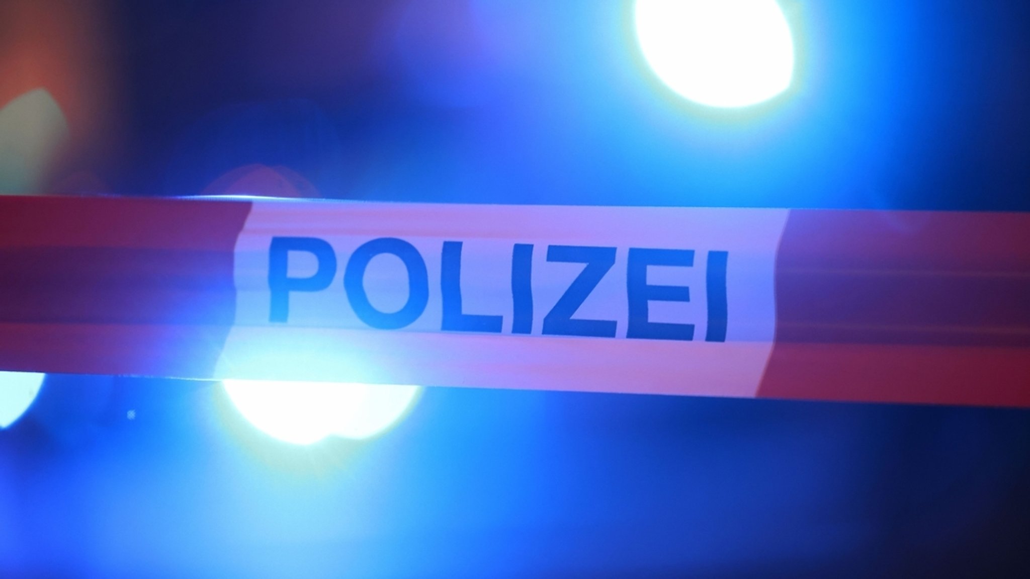 Blaulichter leuchten hinter einem Absperrband der Polizei. | Bild: dpa-Bildfunk/David Young Blaulichter leuchten hinter einem Absperrband der Polizei.