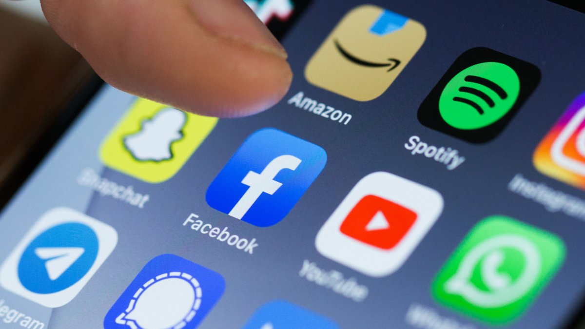 Symbolbild: Ein Daumen tippt auf ein Icon auf einem Smartphone-Bildschirm. Dort sind verschiedene Apps wie Snapchat, Facebook, Youtube, Whatsapp oder Instagram zu sehen. (Symbolbild)