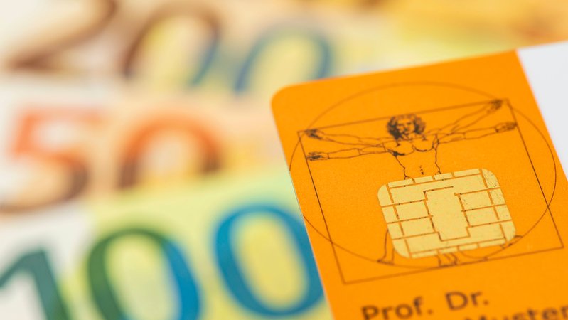 Eine Gesundheitskarte mit Chip liegt über Euro Banknoten. | Bild: pa/SZ Photo/Wolfgang Filser Eine Gesundheitskarte mit Chip liegt über Euro Banknoten.