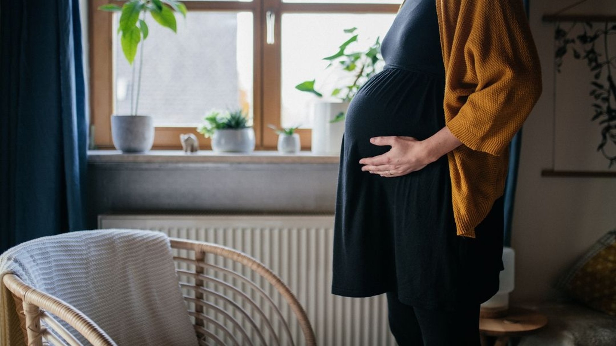 Eine schwangere Frau in ihrem Wohnzimmer