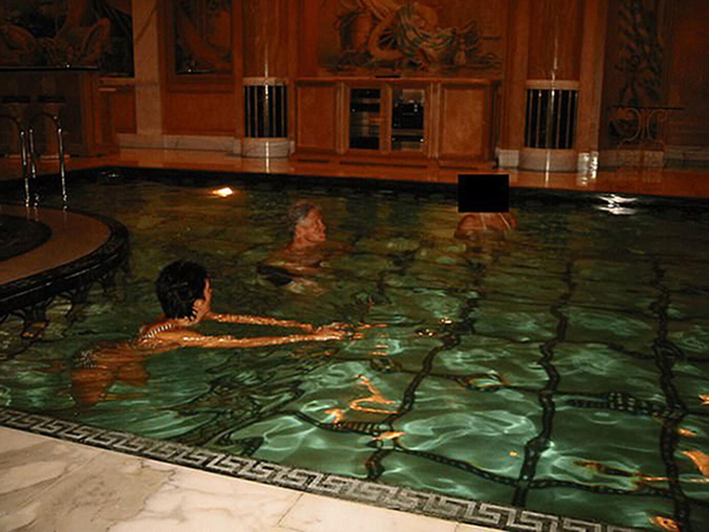 Bill Clinton mit Ghislaine Maxwell und einer Frau, deren Gesicht geschwärzt wurde, in einem Pool. 