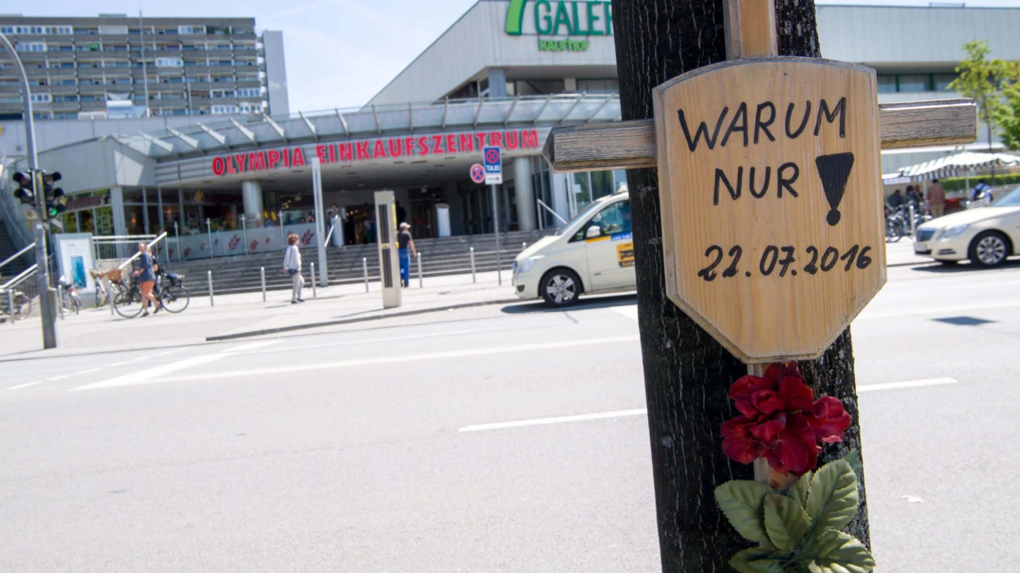 Holzkreuz an einem Baum  vor dem OEZ mit der Aufschrift "Warum nur"