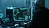 Ein Mann sitzt mit Kapuze vor einem PC und hackt. Bei einem großen Cyberangriff sind Daten von Krankenhäusern und sozialen Einrichtungen in ganz Schwaben gestohlen worden. (Symbolbild) | Bild:stock.adobe.com/Gorodenkoff