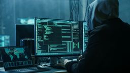 Ein Mann sitzt mit Kapuze vor einem PC und hackt. Bei einem großen Cyberangriff sind Daten von Krankenhäusern und sozialen Einrichtungen in ganz Schwaben gestohlen worden. (Symbolbild) | Bild:stock.adobe.com/Gorodenkoff