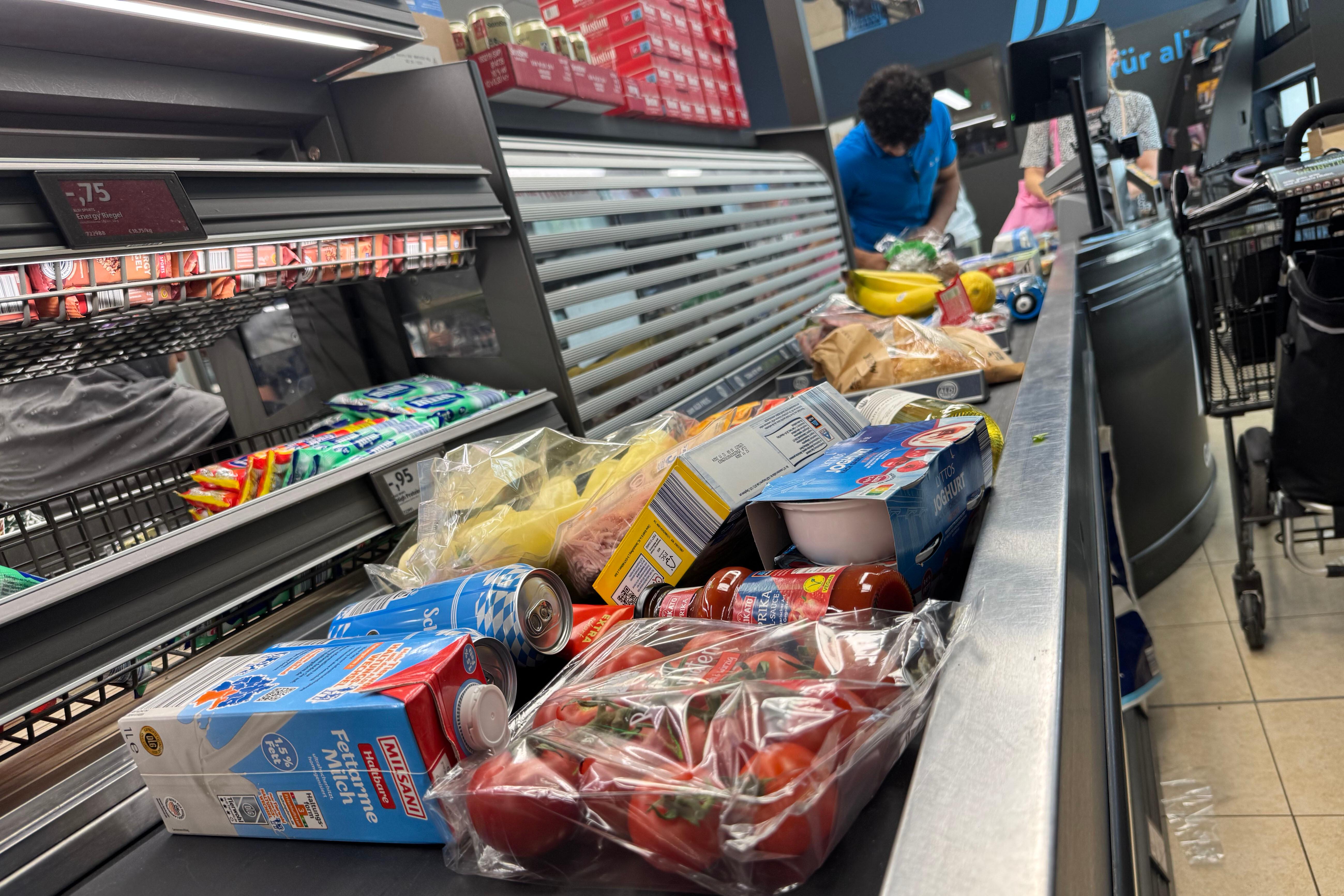 Symbolbild: Produkte liegen bei Aldi Sued auf einem Kassenband 