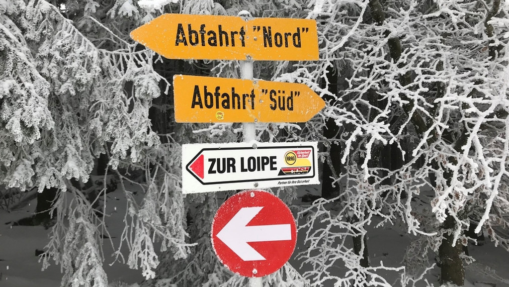 Schilder mit der Aufschrift "Abfahrt 'Nord'", "Abfahrt 'Süd'" und "Zur Loipe".