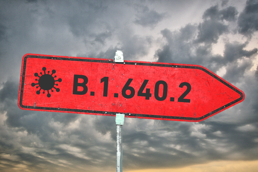 Rotes Straßenschild vor dunklen Wolken mit der Aufschrift "B.1.640.2" - Symbolbild für die neue Virusvariante