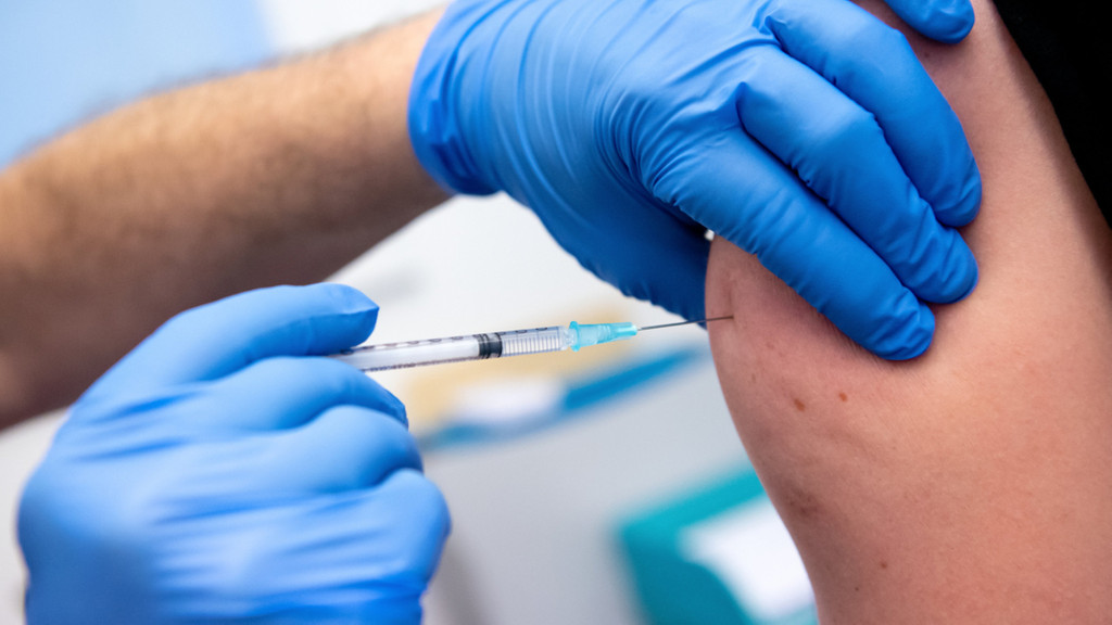 Mann mit wird mit Biontech/Pfizer-Impfstoff in den Oberarm geimpft