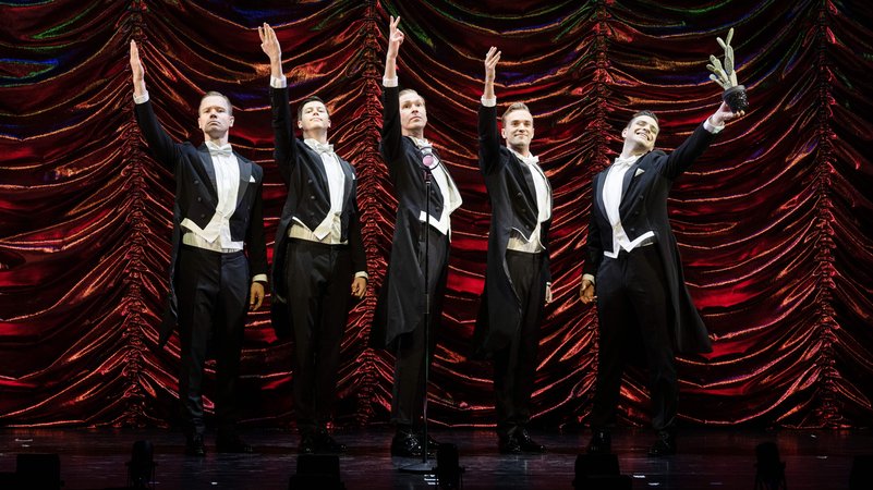 Fünf Männer im Frack vor dunkelrotem Satin-Vorhang | Bild: Christian Kleiner/Deutsches Theater München Fünf Männer im Frack vor dunkelrotem Satin-Vorhang