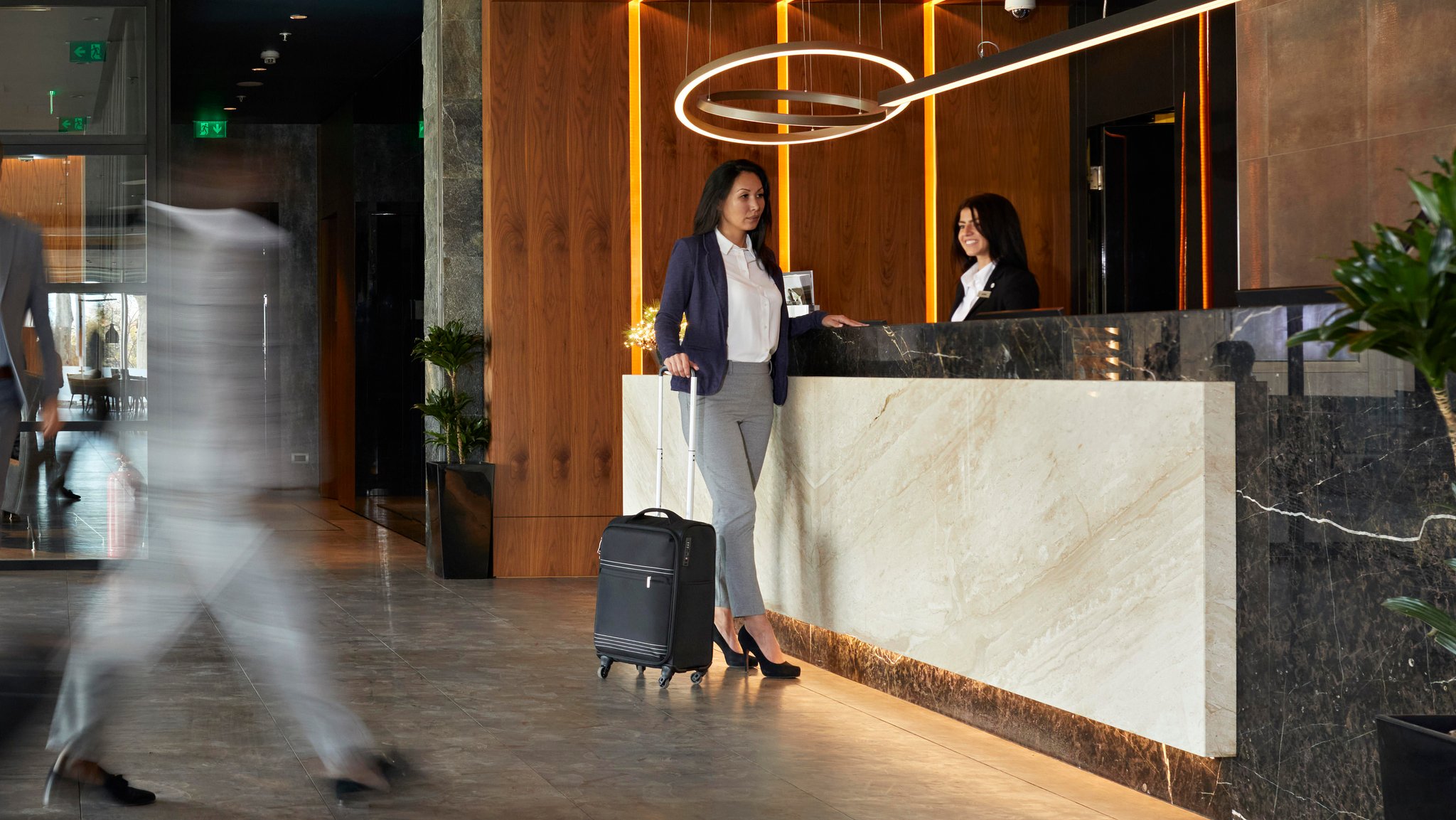 Eine Frau checkt an einer Hotel-Rezeption ein