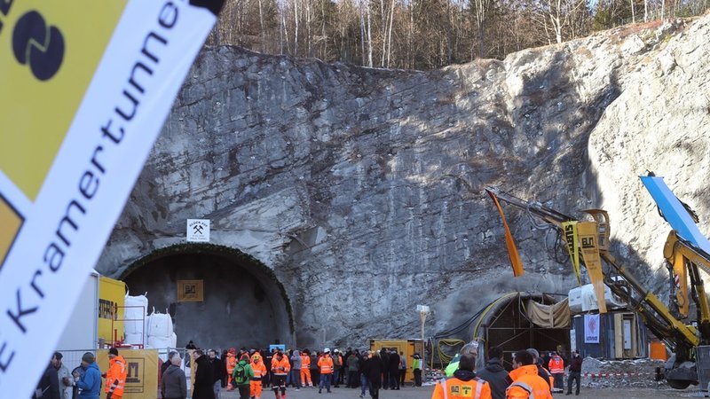 Arbeiter und Gäste stehen nach dem offiziellen Tunnelanschlag im Februar 2002 vor dem zukünftigen Nordportal des Kramertunnels. 