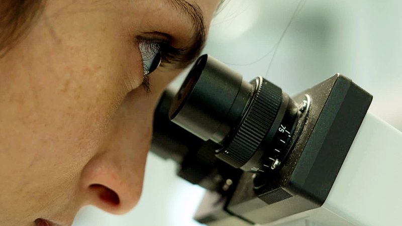 Wissenschaftlerin sieht durch Mikroskop